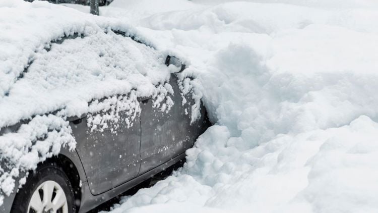 Bildet viser en bil som er begravd i snø