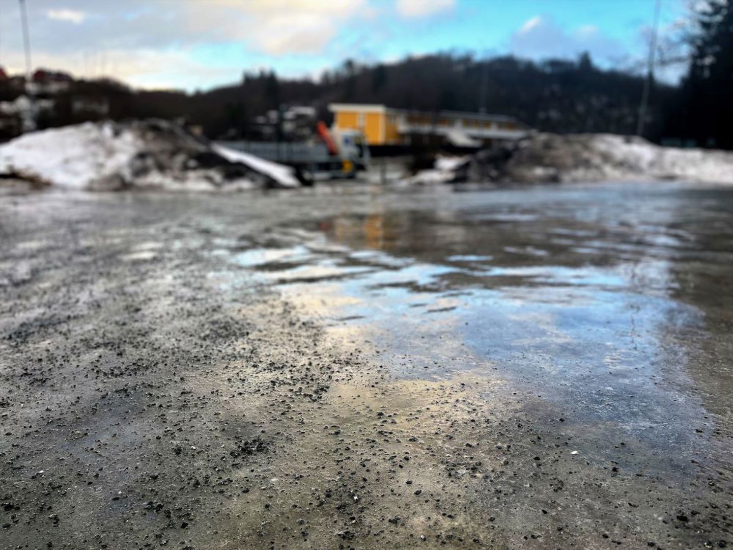 Bildet viser en islagt bakke som delvis er strødd med strøsand. 