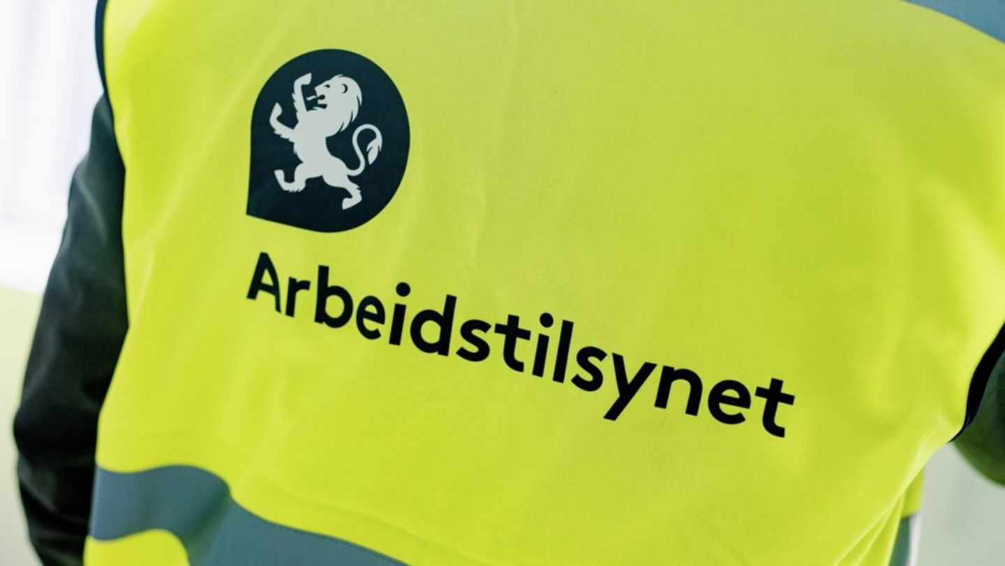 Bildet viser en gul vest med Arbeidstilsynet-logo