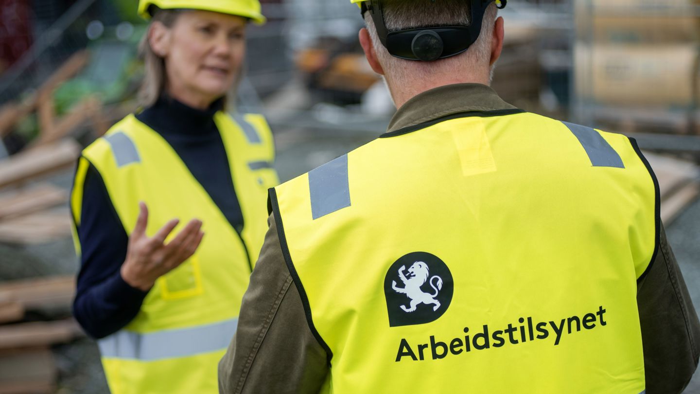 Bildet viset to inspektører med gul vest som er på tilsyn på en byggeplass.