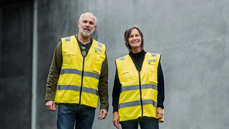 Bildet viser en mann og en kvinne med gule vester.