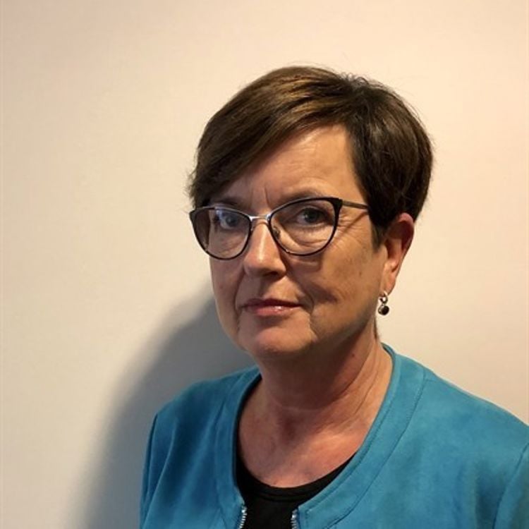 Portrettfoto av kvinne med briller og brunt hår 