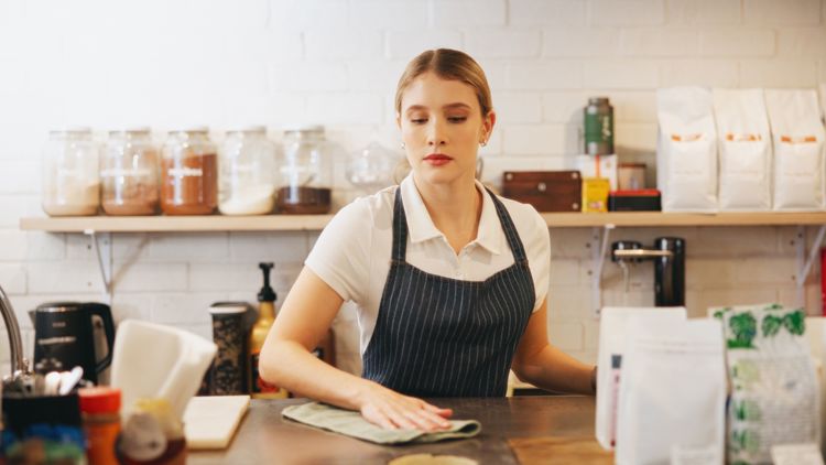 Bildet viser en ung kvinne som jobber på en kafe.